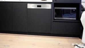 A modern kitchen with a built-in dishwasher, a microwave, and a sink. - Stylish, Cosy City Retreat in Reid Canberra (Reid)