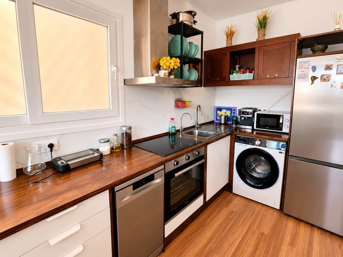 Eine kompakte Küche mit Geschirrspüler, Backofen, Mikrowelle und integriertem Waschmaschine.