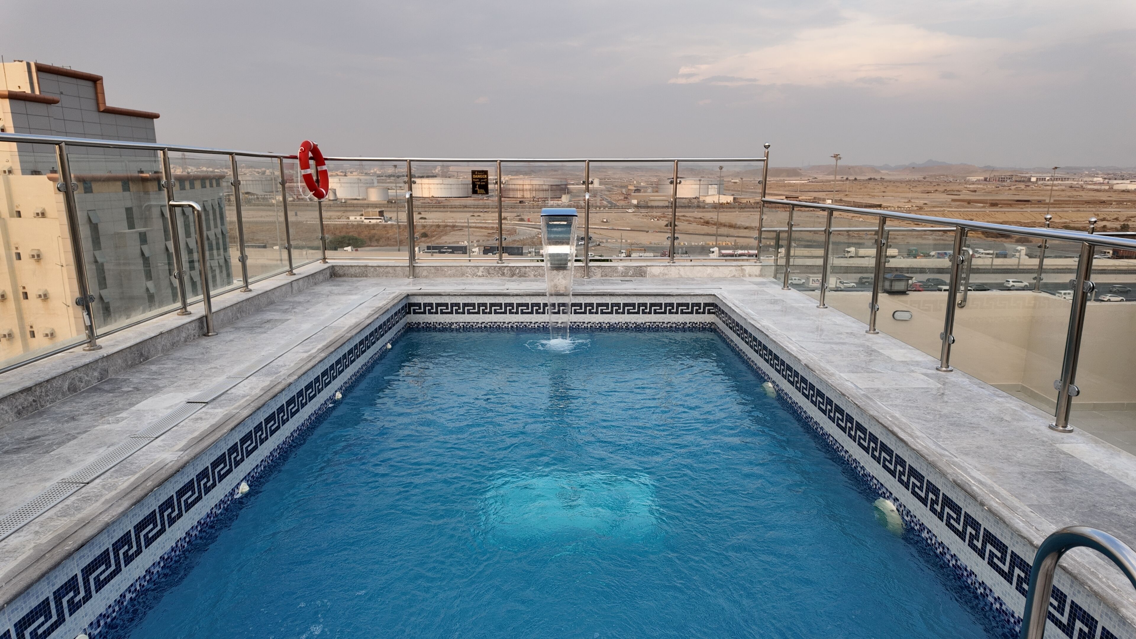 A rooftop swimming pool with a clear view of the surrounding landscape.