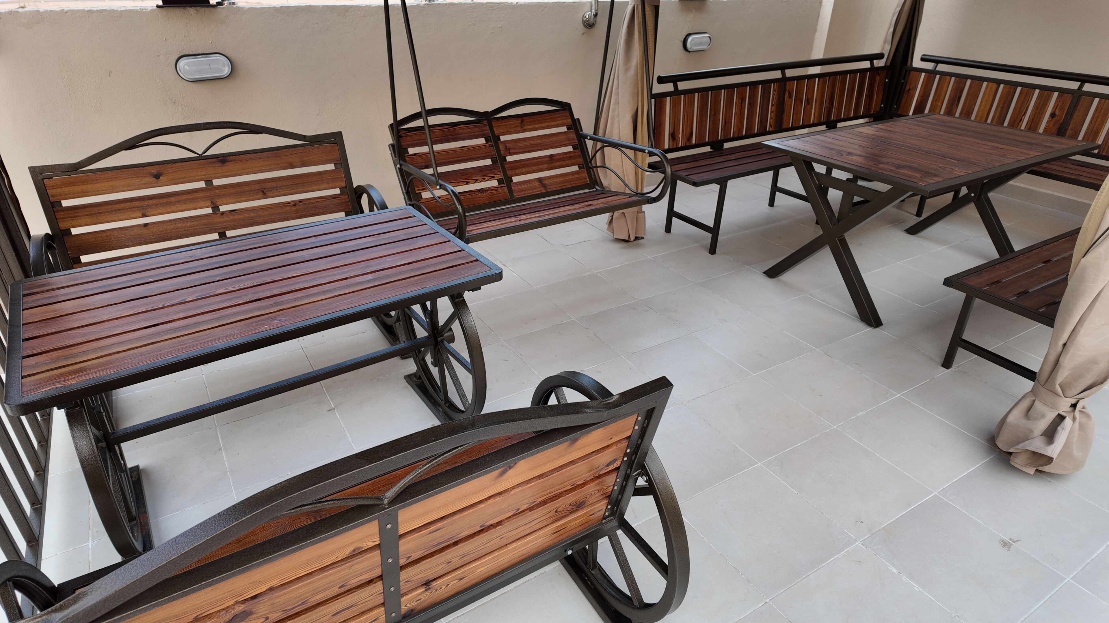 A patio area with wooden furniture including tables and benches.