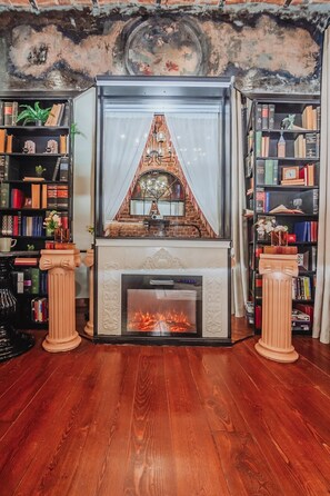 A fireplace with a decorative mantel, flanked by bookshelves on either side. - Allegory of Taksim 2B (İstanbul)