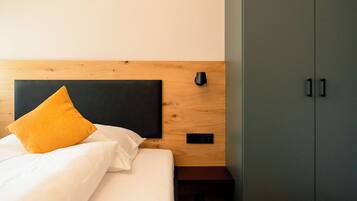 Ein Schlafzimmer mit einem Bett, einem Holzkopfende, einem Kleiderschrank und einem Nachttisch.