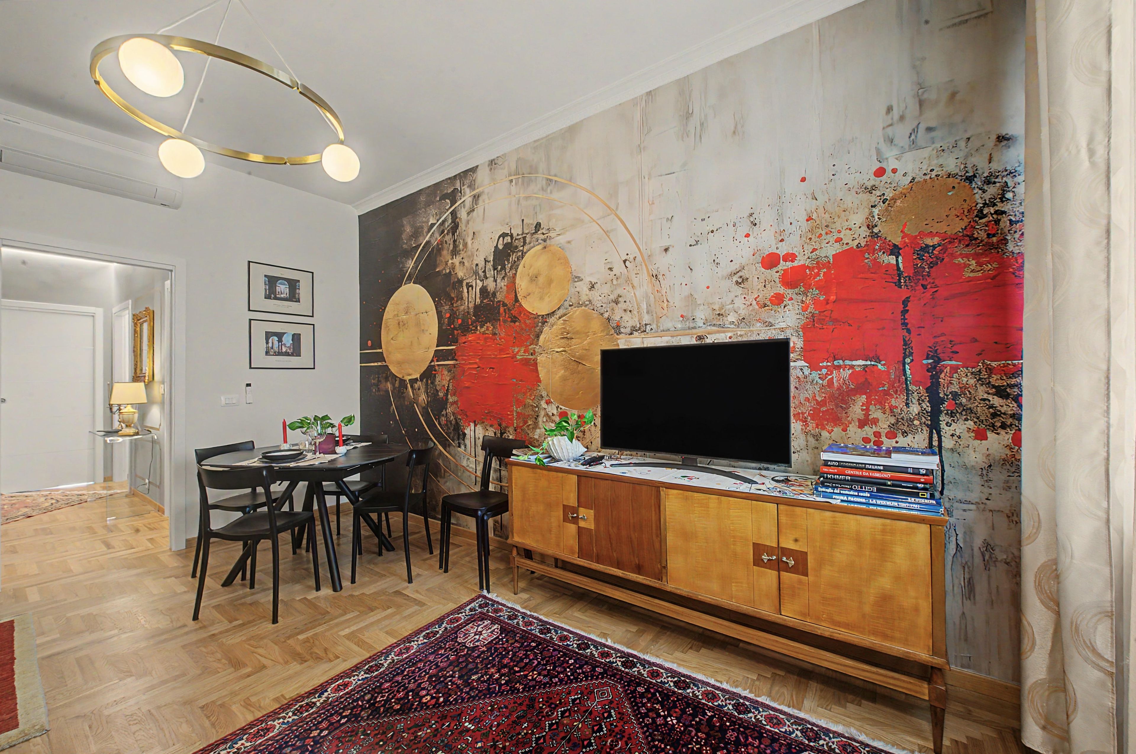 A modern living room with a large abstract painting, a flat-screen TV, and a wooden cabinet.