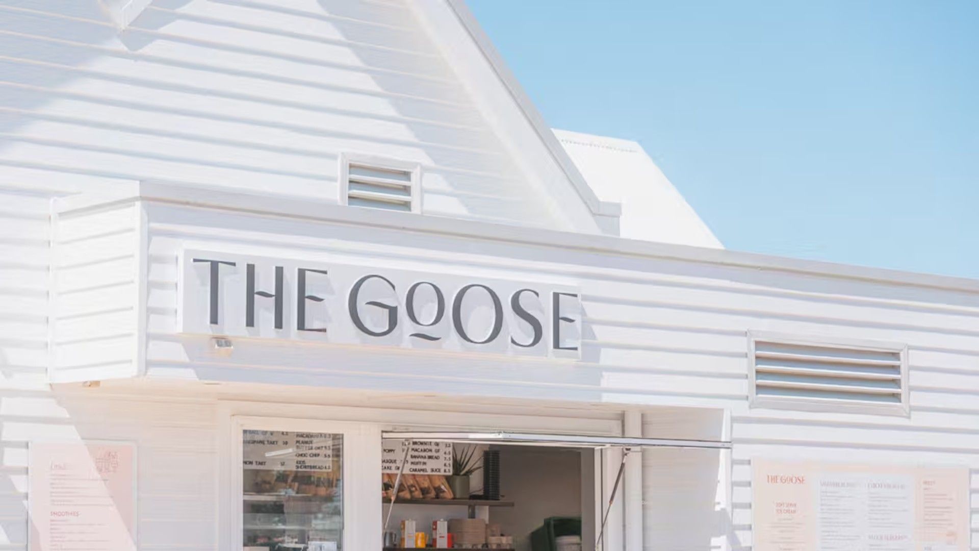 Un edificio con un cartello che riporta la scritta 'THE GOOSE', indicando un'attività commerciale.