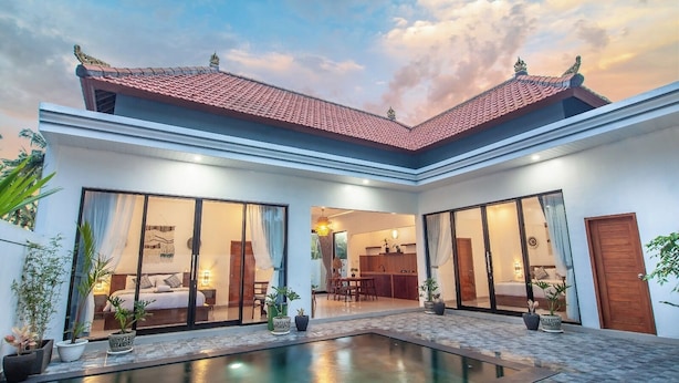 A modern villa with a swimming pool, large sliding glass doors, and a kitchen area. - Ramasita Villa by Bali Sukha (Ubud)