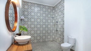 A bathroom with a white sink, a mirror, a toilet, and patterned tiles. - Ramasita Villa by Bali Sukha (Ubud)