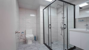 A modern bathroom with a glass shower enclosure, a toilet, and a sink with a mirror above. - 7 Brothers Hotels (Marmaris)