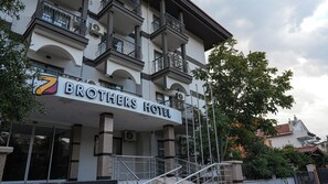 Um edifício com vários andares e uma placa com a inscrição 'Brothers Hotel'.