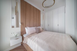 A bedroom with a bed, bedside tables, a mirror, and a wardrobe. - Chmielna Duo Elegant | Warsaw Center & Parking (Warszawa)