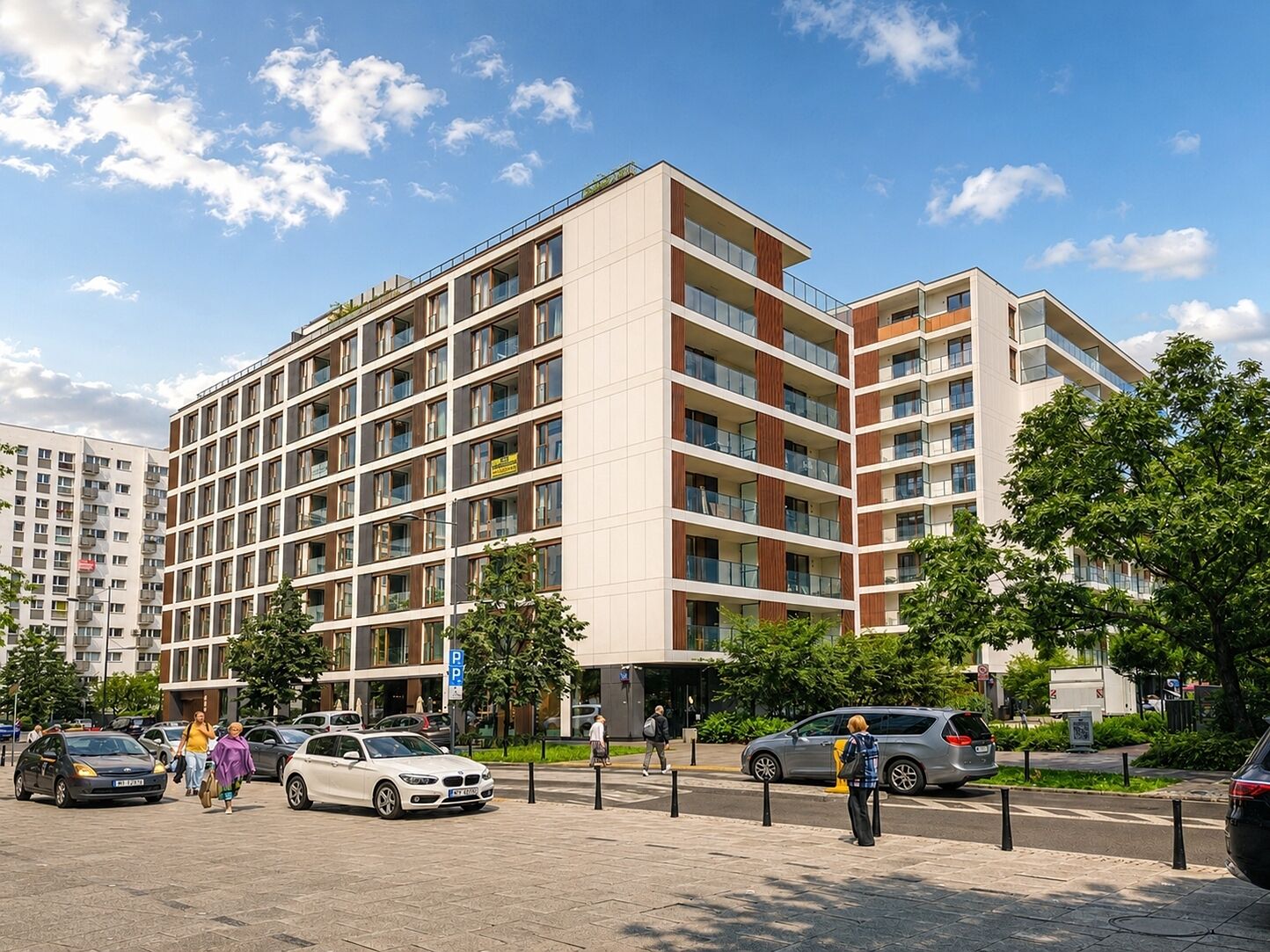 A multi-story residential building with a modern design, featuring balconies and large windows.