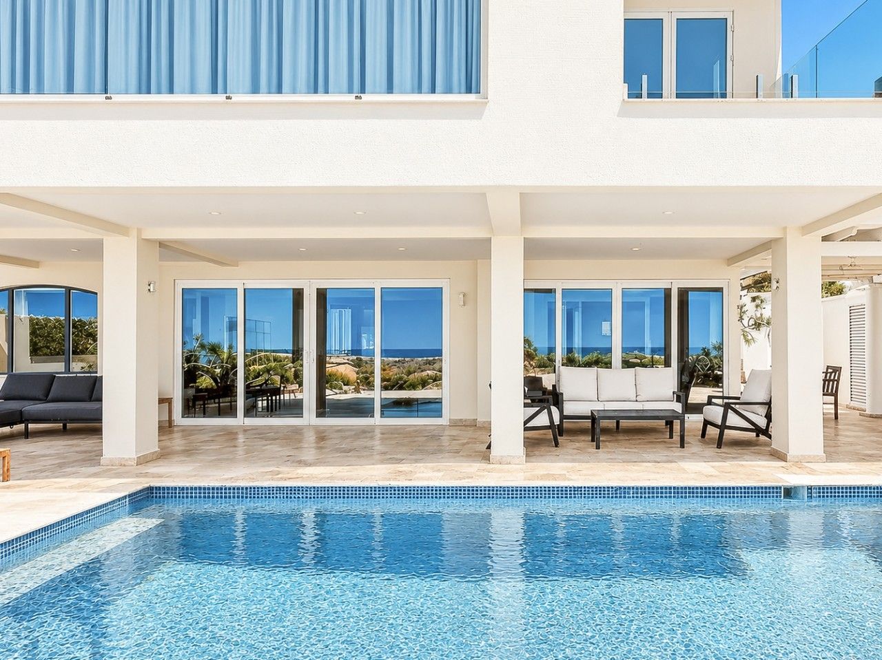 Dine outdoors beneath the covered terrace, featuring a beautiful wooden dining table and a relaxed setting for meals in the Caribbean breeze.BA27-1487E2E84C69