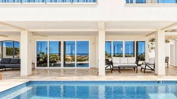 Dine outdoors beneath the covered terrace, featuring a beautiful wooden dining table and a relaxed setting for meals in the Caribbean breeze.BA27-1487E2E84C69