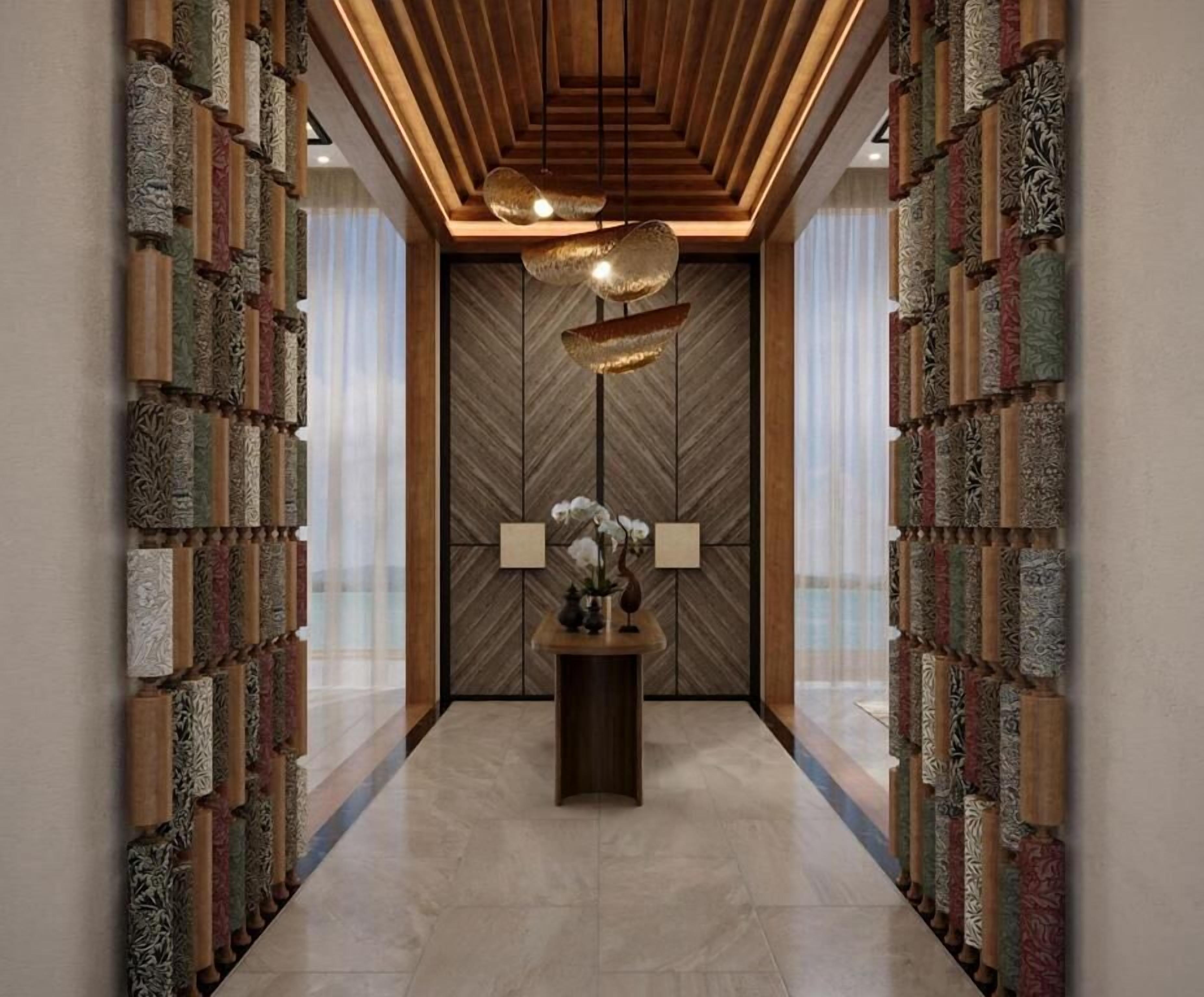 Un couloir aux murs ornés de panneaux décoratifs, une table centrale agrémentée d’un vase et de lampes, et un plafond en bois doté d’un éclairage encastré.