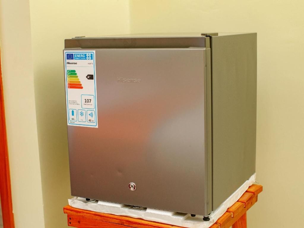 A Hisense refrigerator with an ENERGY STAR label, placed on a wooden stand.