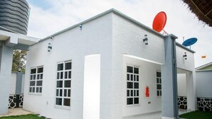 A modern building with a white exterior, large windows, and satellite dishes on the roof.