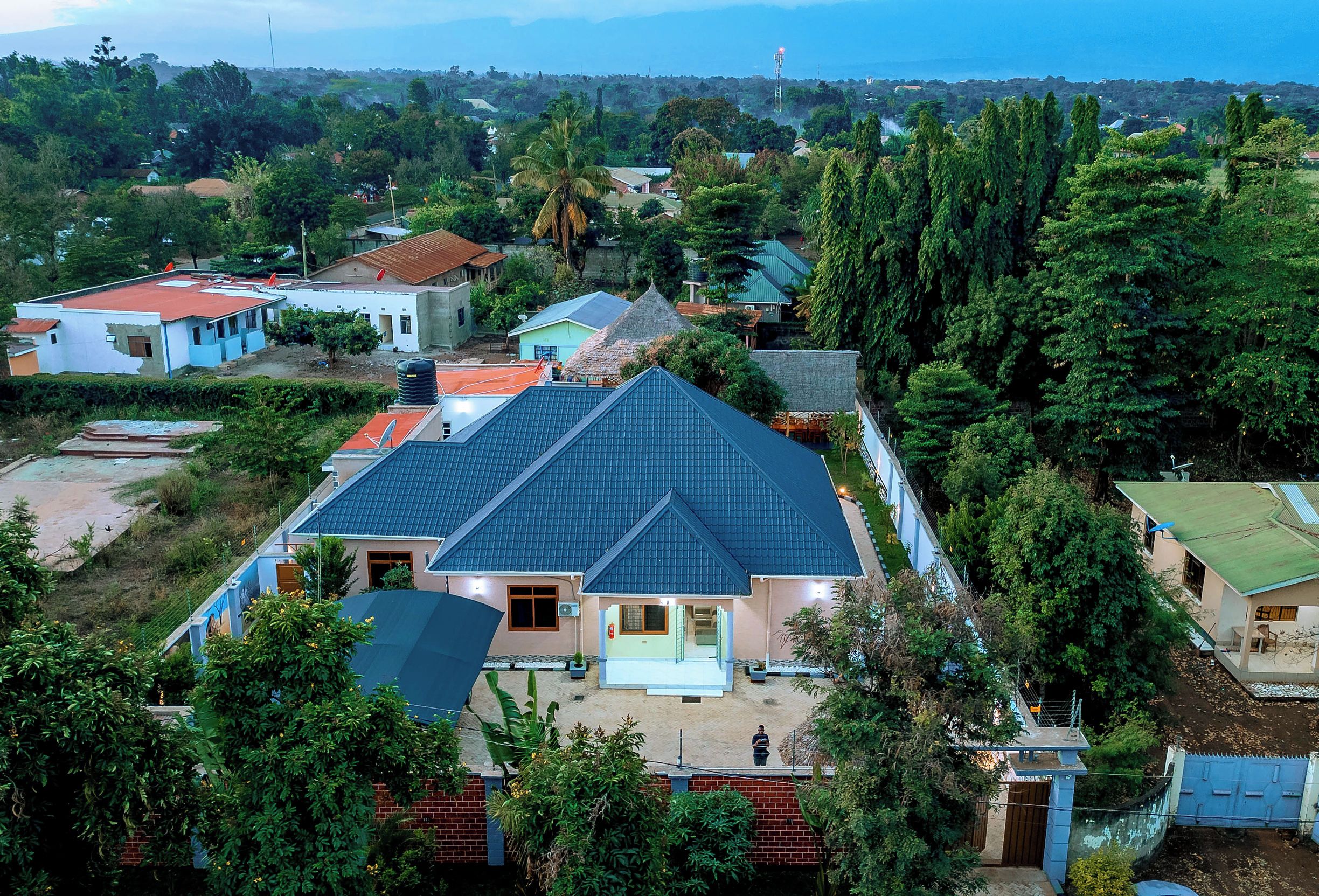 Zona residencial con casas, algunas con antenas parabólicas, rodeada de vegetación y árboles.