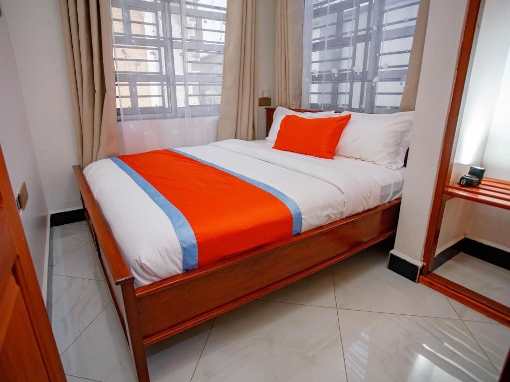 A hotel room with a bed, curtains, and a window with a view.