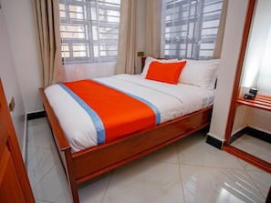 A hotel room with a bed, curtains, and a window with a view. - Salpat Camp Lodge (Moshi)