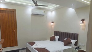 A hotel room with a bed, bedside table, nightstand, and a ceiling fan.