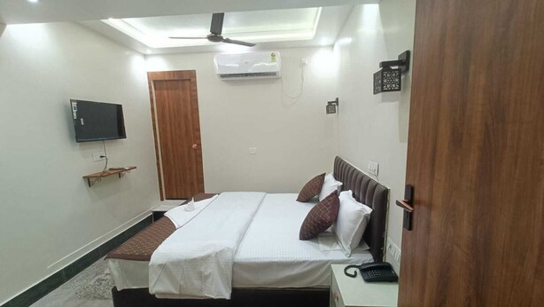 A bedroom with a bed, bedside table, and a ceiling fan.