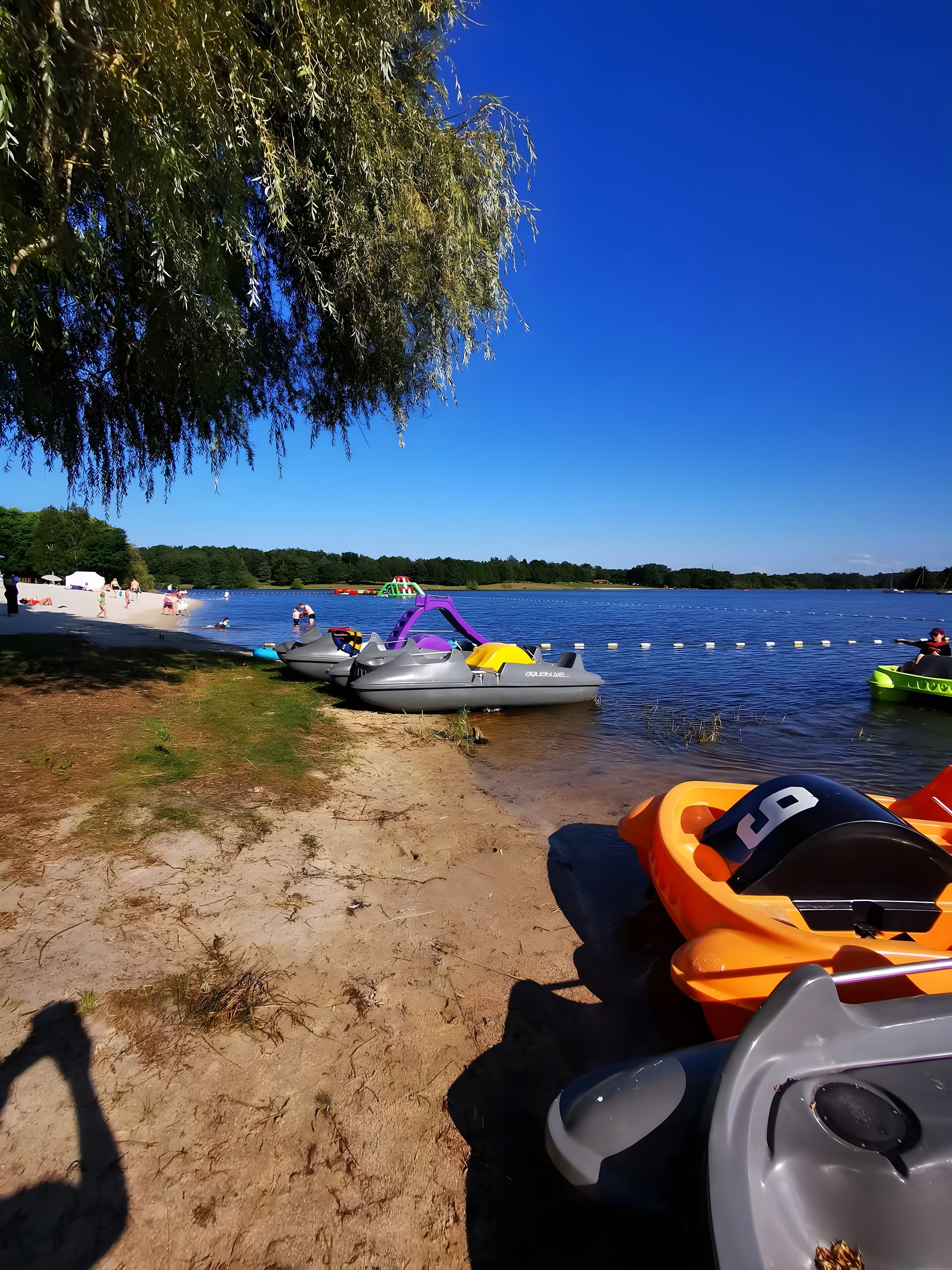 Una zona junto al lago con barcos y una playa de arena.