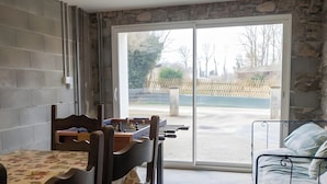 Una habitación con una mesa de comedor, sillas, un sofá y un amplio ventanal con vistas al exterior.