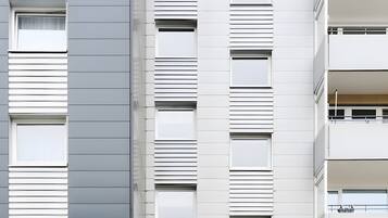 Ein modernes, mehrstöckiges Gebäude mit flacher Fassade, großen Fenstern und einem befestigten Eingangsbereich.