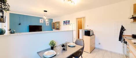 A compact kitchen with a dining area, a microwave, and a small refrigerator.