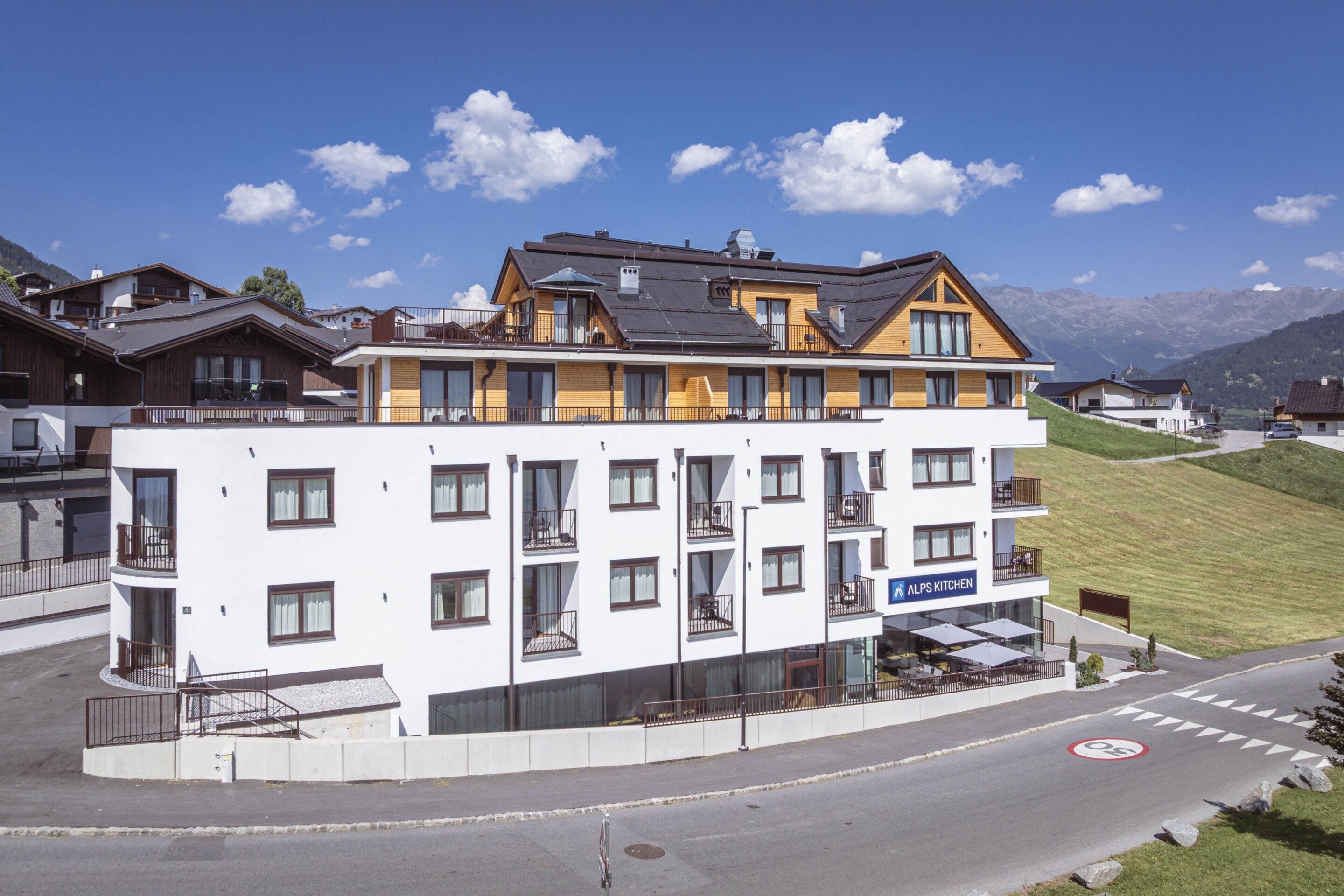 Een modern hotel met meerdere verdiepingen, balkons en een restaurantruimte.