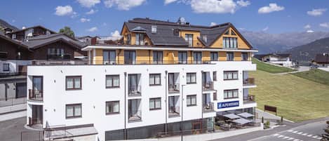 Een modern hotel met meerdere verdiepingen, balkons en een restaurantruimte.