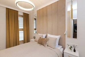 A modern bedroom with a large bed, a bedside table, a mirror, and a window with curtains. - Chmielna Duo Luxury | Warsaw Center & Parking (Warszawa)