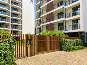 A multi-story residential building with balconies, a gated entrance, and a well-maintained garden. - Chmielna Duo Luxury | Warsaw Center & Parking (Warszawa)