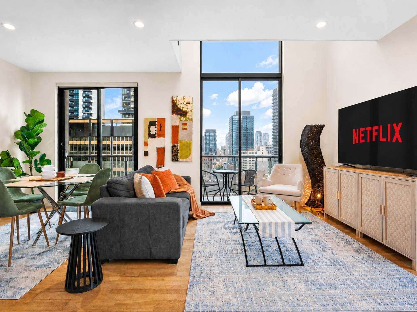 A modern living room with a sofa, chairs, a coffee table, and a television.