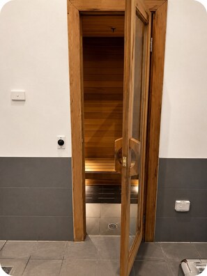 A wooden door leading to a room with a tiled floor and a light switch on the wall. - Gem by the mall, Pool, Gym, Parking, WIFI (Melbourne)