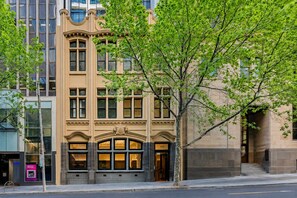 A historic building with a prominent entrance, large windows, and a tree in front. - City Centre on Best Street, Gym, WI-FI, Parking (Melbourne)