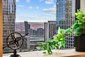 A view from a high-rise building with a clear sky, featuring modern architecture and a distant view of a stadium. - City Centre on Best Street, Gym, WI-FI, Parking (Melbourne)