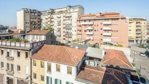 Un immeuble résidentiel de grande hauteur, doté de nombreux balcons et d’un toit plat.