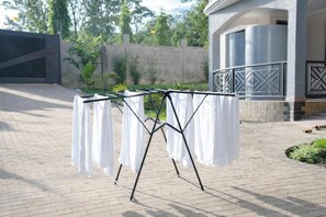 Un tendedero metálico con ropa blanca en un entorno exterior.
