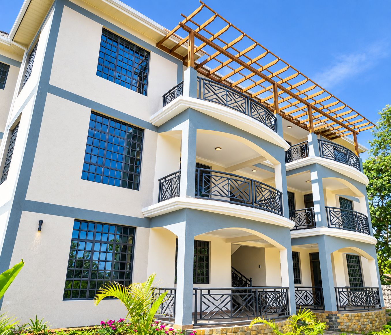 A multi-story building with balconies, large windows, and a covered outdoor area.