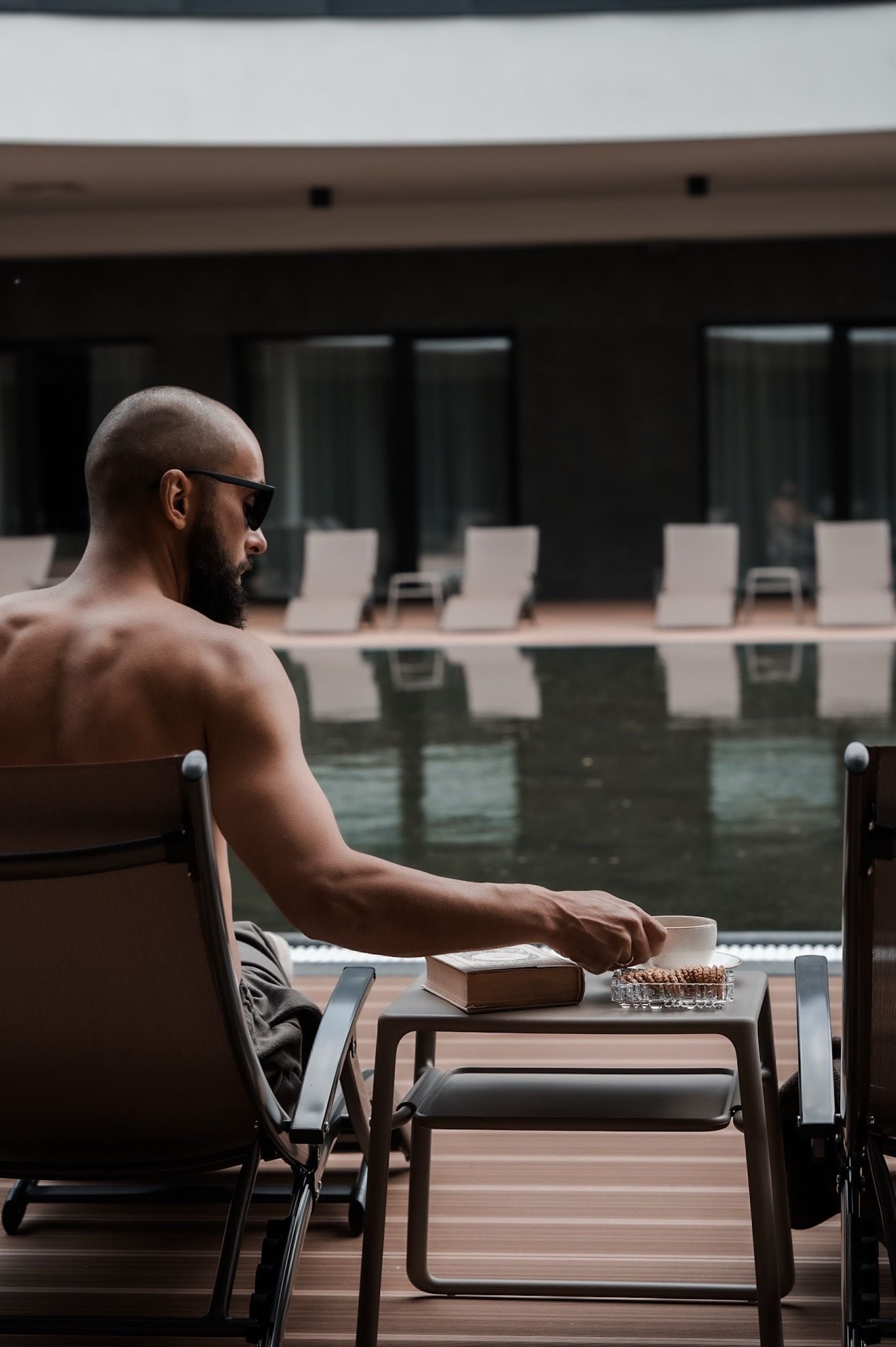 Ein Mann sitzt an einem Pooltisch mit einem Buch und einer Schüssel Nüssen.