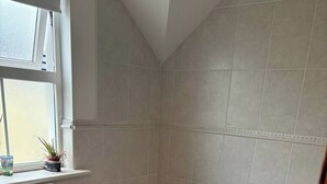 A bathroom with a toilet, bathtub, and sink. - Charming 4-bedroom House in Skibbereen - Pet Friendly Retreat (Skibbereen)