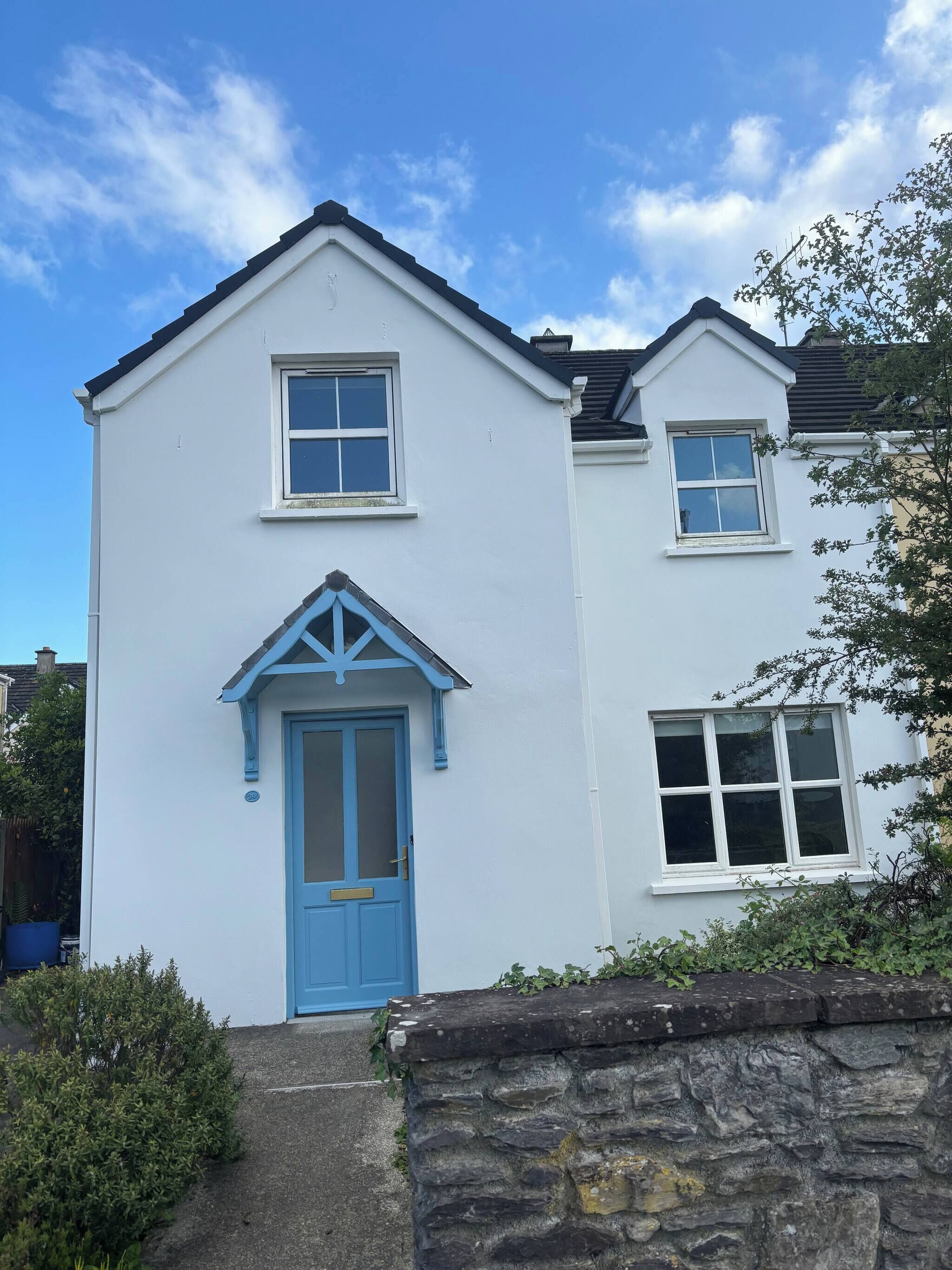 A two-story house with a blue door and windows.