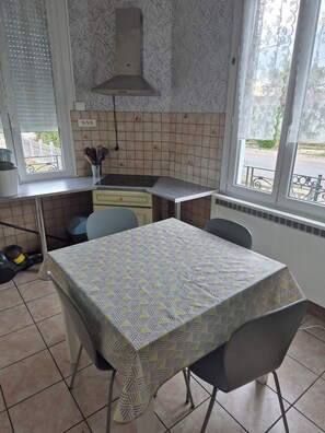 Une cuisine équipée d’une table à manger, de chaises, d’une cuisinière et d’une fenêtre donnant sur un beau paysage.