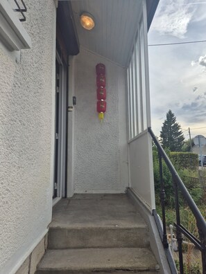 A concrete staircase leading to a door with a red lantern hanging on the wall. - Large village house, 90 m² – Sleeps 10 – Lac du Der – 8 km from Saint-Dizier (Hallignicourt)