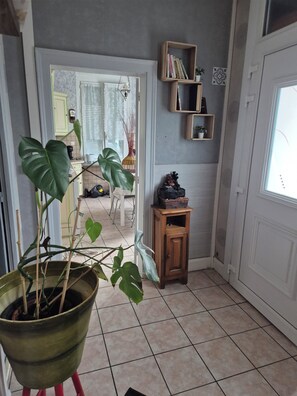 A hallway with a potted plant, a small wooden cabinet, and a door leading to another room. - Large village house, 90 m² – Sleeps 10 – Lac du Der – 8 km from Saint-Dizier (Hallignicourt)