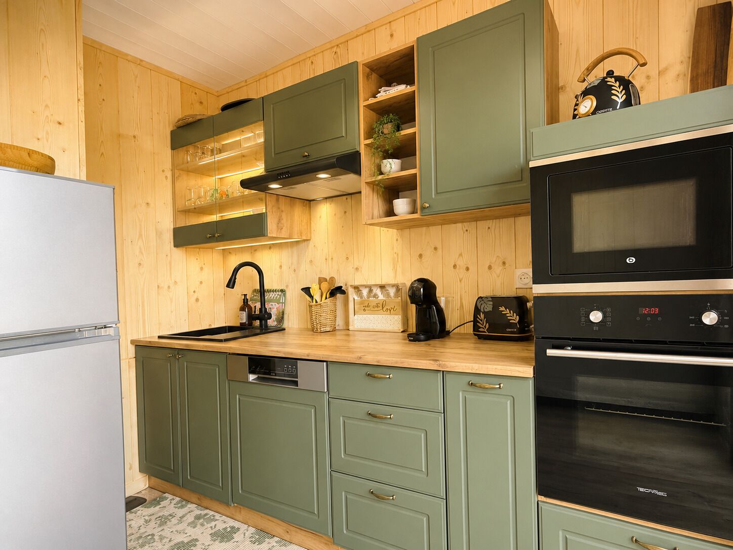 A kitchen with wooden cabinets, a built-in oven, and a coffee maker.