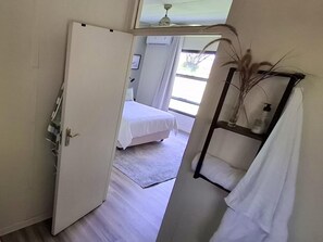 Habitació d'hotel amb un llit, un bany amb penjador de tovalloles i una finestra amb llum natural.
