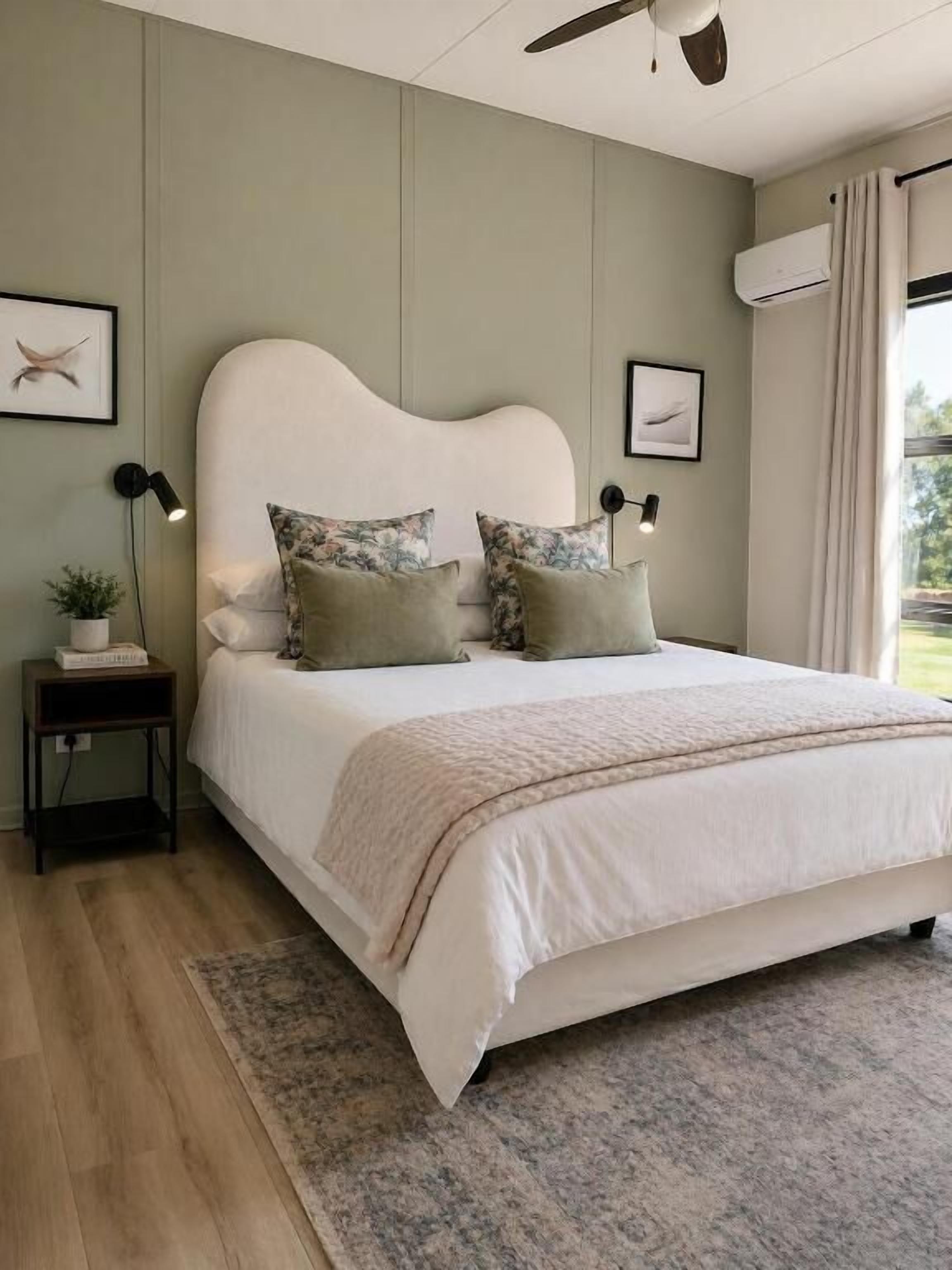 A bedroom with a bed, bedside tables, a ceiling fan, and a window with curtains.