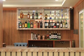 A bar area with shelves of liquor bottles and glasses. - Junction Hotel (Kathmandu)