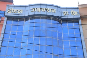 A hotel building with a modern glass facade and signage in a non-English script. - Junction Hotel (Kathmandu)